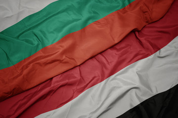 waving colorful flag of yemen and national flag of bulgaria.