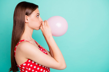 Profile side photo of astonished girl inflating balon looking wondering wearing polka dot dress...