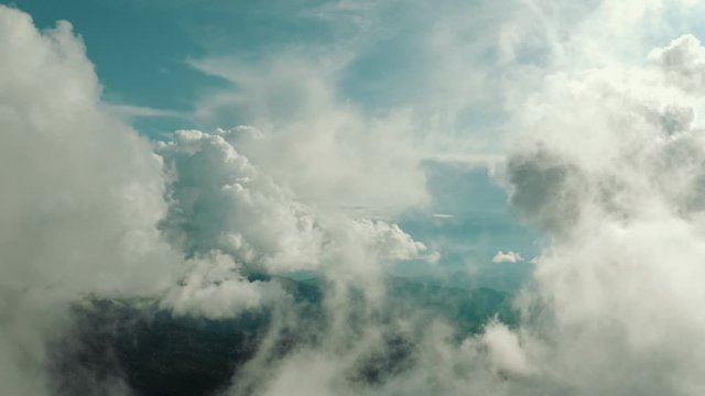 The flight in beautiful clouds above mountains