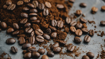 Coffee beans with ground coffee heap. Arabic roasted coffee on rock, Marble plate and dark background.