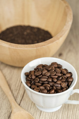 Fototapeta na wymiar Coffee beans in coffee cup on wood table background.