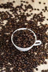 Fototapeta na wymiar Coffee beans in coffee cup on wood table background.