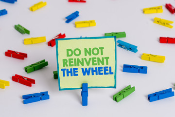 Conceptual hand writing showing Do Not Reinvent The Wheel. Concept meaning stop duplicating a basic method previously done Colored clothespin papers empty reminder white floor office