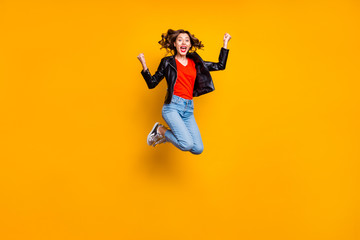 Fototapeta na wymiar Full body photo of cheerful cute girl raise her fists scream yeah jump celebrate achievement wear denim jeans outfit isolated over yellow color background