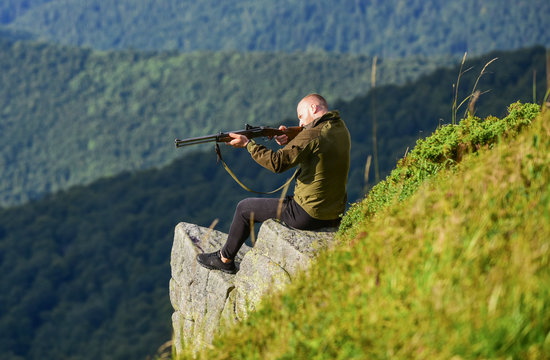 Hunting masculine hobby concept. Regulation of hunting. Focused on target. Hunter hold rifle. Hunter spend leisure hunting. Man brutal gamekeeper nature landscape background. Hunting in mountains