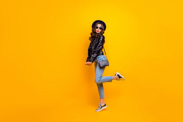 Fototapeta na wymiar Full length photo of charming funky girl have stroll date with her boyfriend send air kisses wear black leather jacket denim jeans isolated over yellow color background