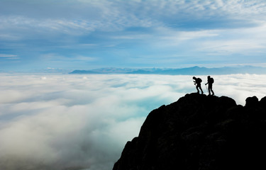 peaks of foggy mountains, professional climber team and successful climb