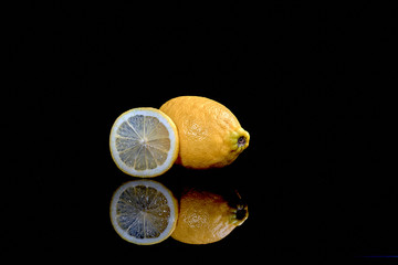 shot of sliced and whole lemons isolated on black background