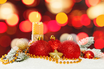 Christmas card background with abstract bokeh light, candle, green fir branch, garland, baubles and white snow