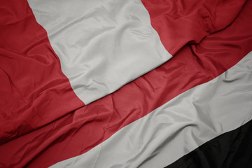 waving colorful flag of yemen and national flag of peru.