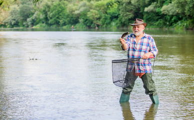 Fisherman fishing equipment. Fisherman alone stand in river water. Pensioner leisure. Man senior bearded fisherman. Hobby sport activity. Fish farming pisciculture raising fish commercially