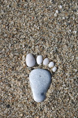 Nice stone made footprint on the sand shore, background