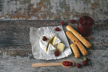Camembert cheese with raspberry sauce and grissini sticks.