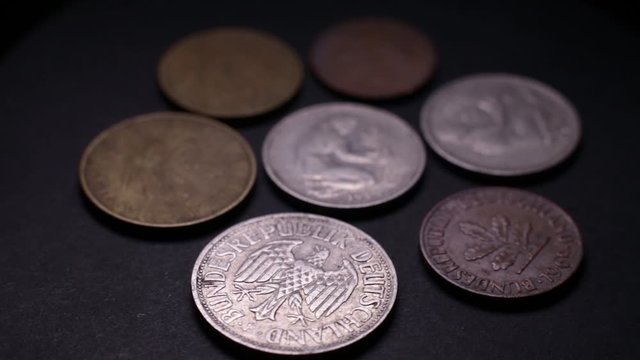 Close Up Of Old German Coins Rotating On Black Background.