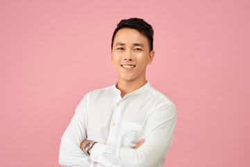 Young Asian male smiling and laughing with arms crossed