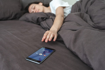 Woman waking up and switch off notification on smartphone