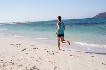 Rear view shot of a jogger on the beach