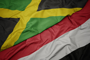 waving colorful flag of yemen and national flag of jamaica.