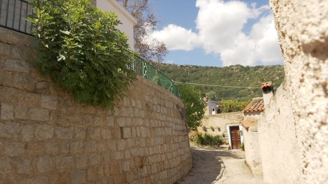 Shot tracking to the left discovering a cobblestone halley od a lonely village in Italy