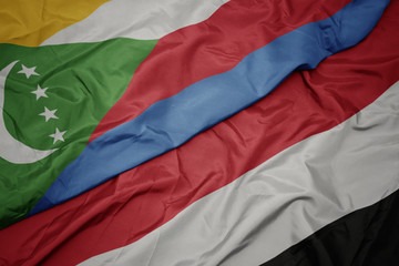 waving colorful flag of yemen and national flag of comoros.