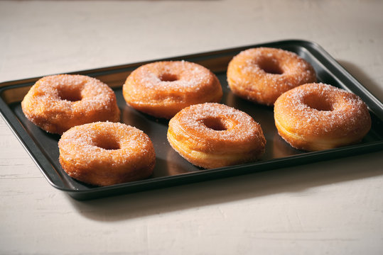 Fried Donuts with Powdered Sugar on metal baking dish