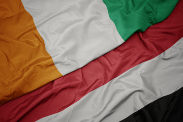 waving colorful flag of yemen and national flag of cote divoire.