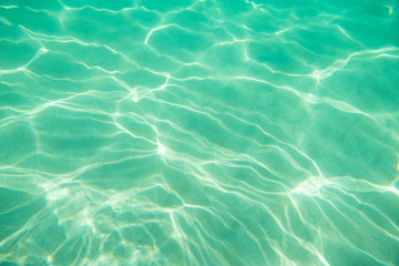 Underwater. Sun glare at the bottom of the seat. Waves underwater and rays of sunlight shining...