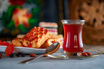 Turkish tea in traditional glass with sweets, dried fruits and nuts for a teatime