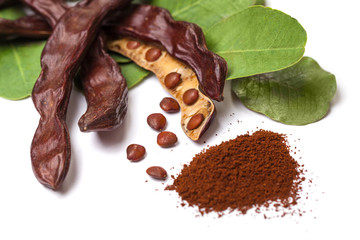 Carob beans. Healthy organic sweet carob pods with seeds and leaves on white background