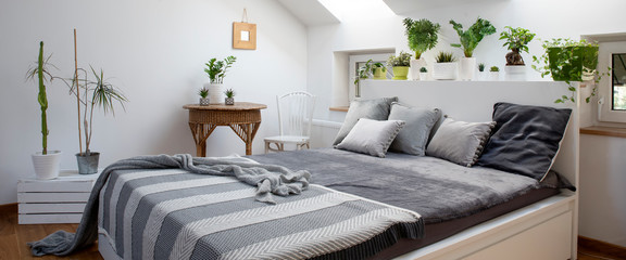 Bright bedroom in white and grey colors in interior of apartment in scandinavian style. Panoramic banner.