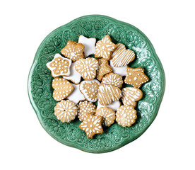 Homemade gingerbread cookies on a green vintage plate isolated on a white background.