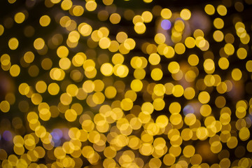 Abstract beautiful blurred gold yellow colored bokeh from ornamental lights flickering in the park. Background for celebrate party, merry Xmas, happy new year concept.