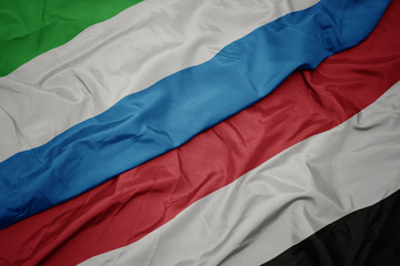 waving colorful flag of yemen and national flag of sierra leone.