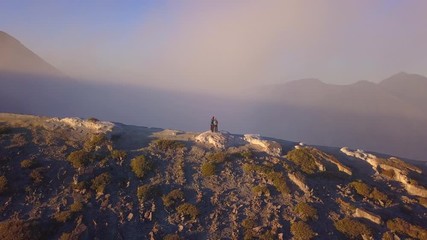 Aerial: People stay on the edge of crater  Kawah Ijen volcano, East Java, Indonesia