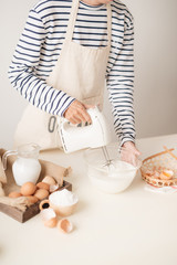 Fototapeta na wymiar Mixing white egg cream in bowl with motor mixer, baking cake