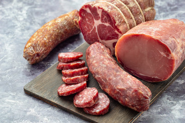 Assortment of delicious deli meats on wooden board