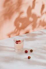 Summer juice with fresh raspberries in a glass on a light background