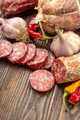 Sliced salami on wooden board.