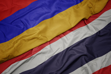 waving colorful flag of thailand and national flag of armenia.