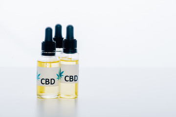 cannabis oil in bottles with lettering cbd on white background