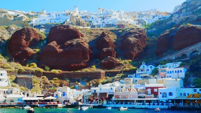 Handheld view of the coastal cliffs of Santorini as seen from a boat on the water..Port of Oia on the Island of Santorini, Cyclades, Greece