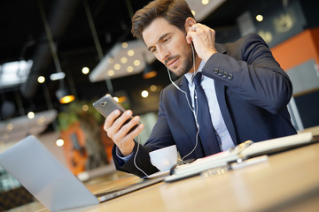 Businessman talking on phone at airport waiting room