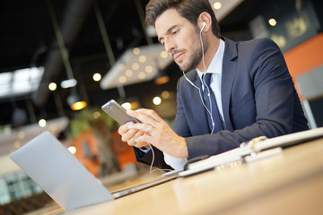 Businessman talking on phone at airport waiting room