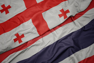 Fototapeta premium waving colorful flag of thailand and national flag of georgia.