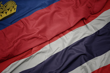 waving colorful flag of thailand and national flag of liechtenstein.
