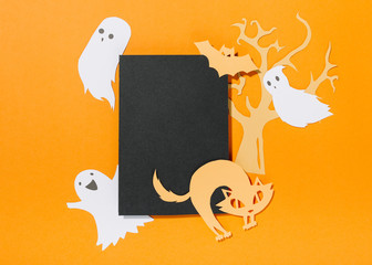 Bat and cat on piece of paper with tree behind and ghosts levitating near