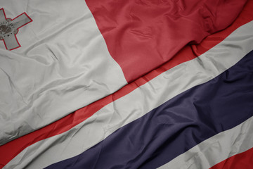 waving colorful flag of thailand and national flag of malta.