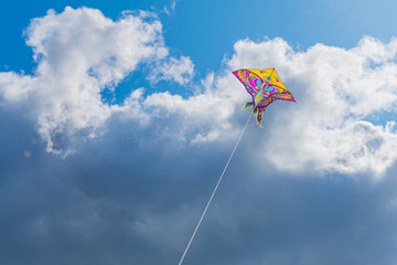 Beautiful colorful butterfly kite against the sky and clouds, freedom vacation travel concept