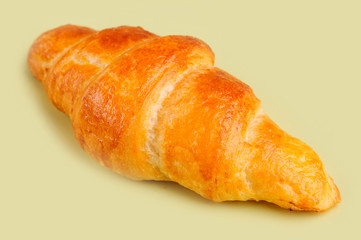 Croissant on yellow board.