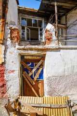 Abandoned shack house with barred shut door and broken glass window